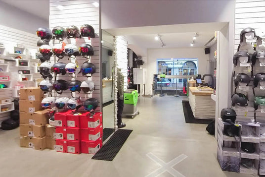 Sportgeschäft mit Auswahl an Skihelmen und Zubehör an der Wand