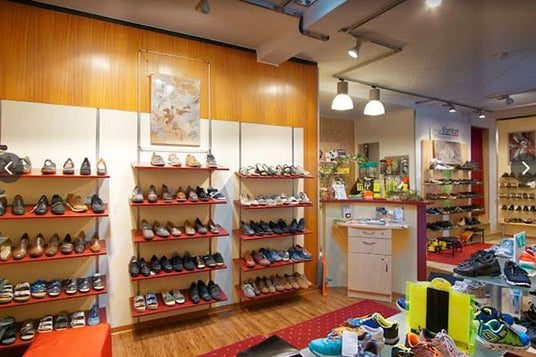 Innenraum eines Schuhgeschäfts mit Regalen voller verschiedener Schuharten