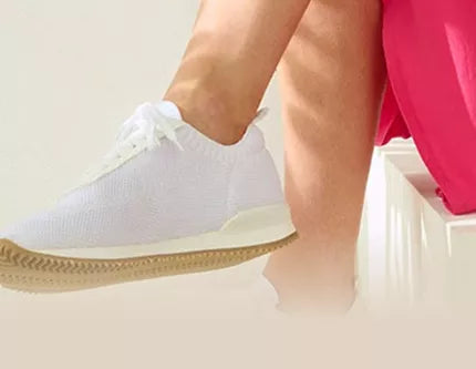 Eine Person sitzt auf einer Treppe und trägt weiße Schuhe neben einem Blatt. Text: Berufsschuhe für Krankenhaus, Praxis und Pflege.