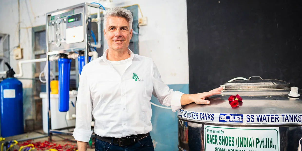 Ein Mann steht in einem technischen Raum und lehnt sich an einen Edelstahltank, der von Baer Shoes gesponsert wurde.